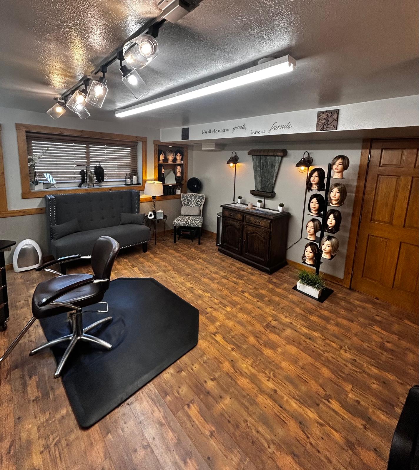 Full salon view — styling chair, shampoo bowl, wig display, and waiting area